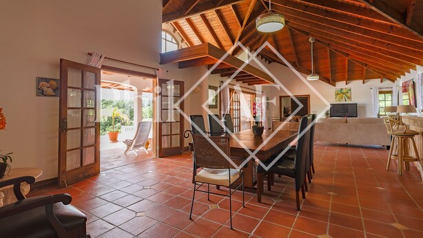 A spacious room with a high ceiling, a dining area with chairs and a table, and a view of the outdoors. - Beautiful 5 bed-rooms Villa at Terres Basses (Saint Martin)