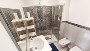 A modern bathroom with a glass shower enclosure, a white sink, a bidet, and a toilet. - Nice apartment not far from the sea (Lacco Ameno)