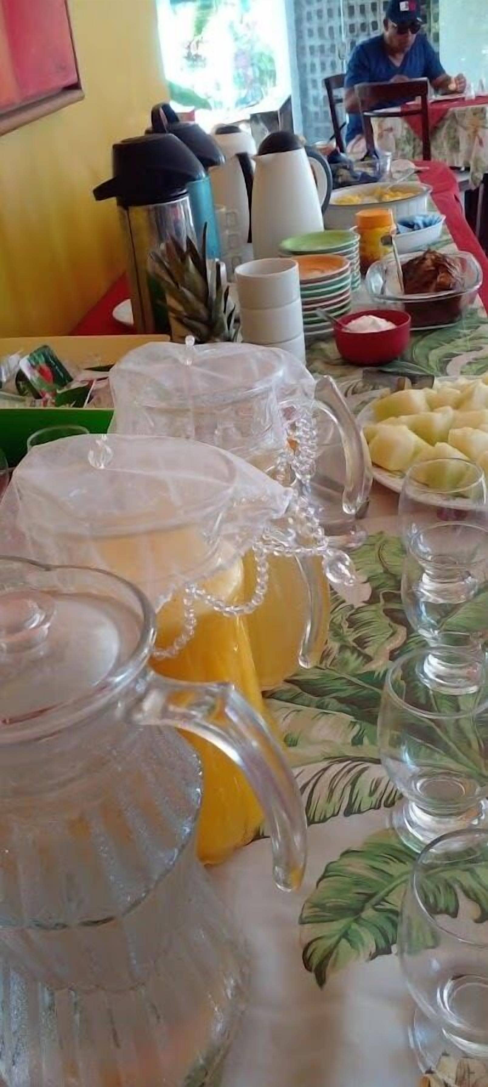 A buffet table with various food items and drink dispensers.