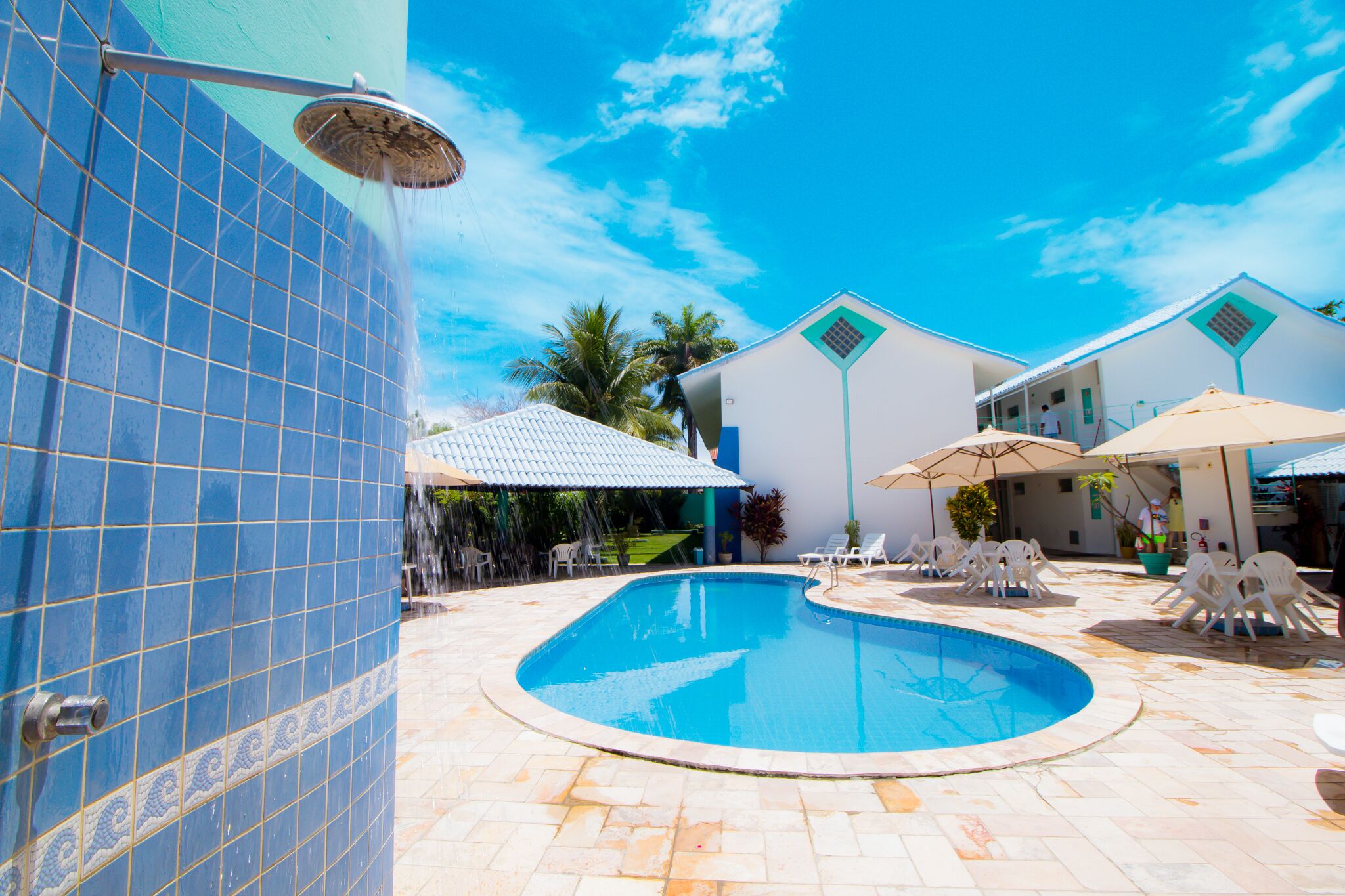 A swimming pool with tiled walls and a clear blue sky.