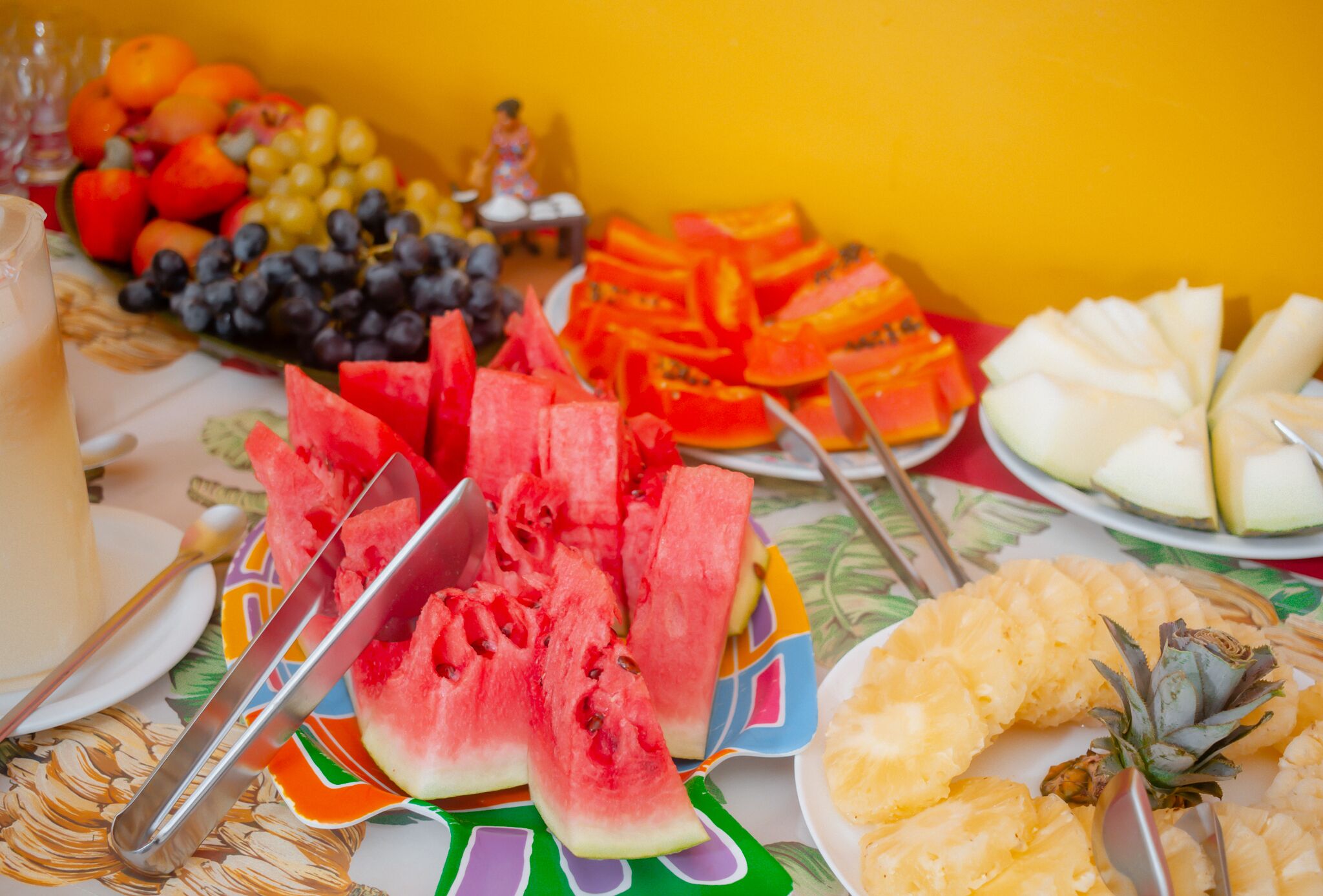 Una mesa con varias frutas y una bebida.