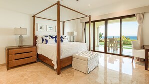 A four-poster bed with a view of the ocean, a side table with a lamp, and a large window with curtains. - TheNest. Oceanview condo with access to infinity pool and jacuzzi (San José del Cabo)