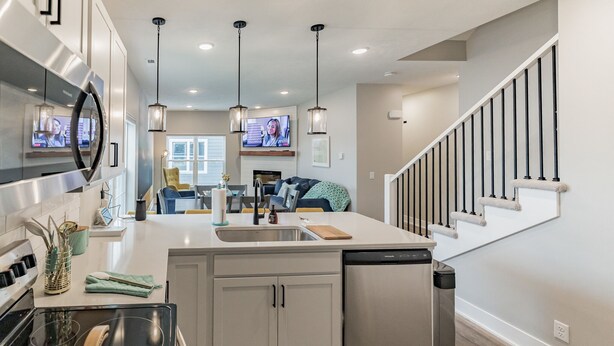 A modern kitchen with stainless steel appliances, a central island, and pendant lighting. - New 3 bed 4 bath home - rooftop deck, 2 car garage & porch near downtown! (Omaha)