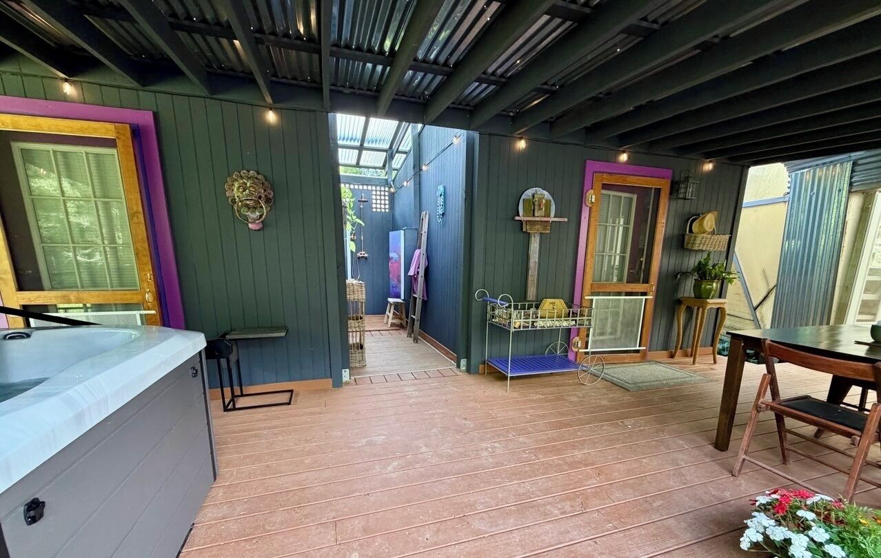 A cozy interior with a wooden floor, a hot tub, and a dining area with a table and chairs.