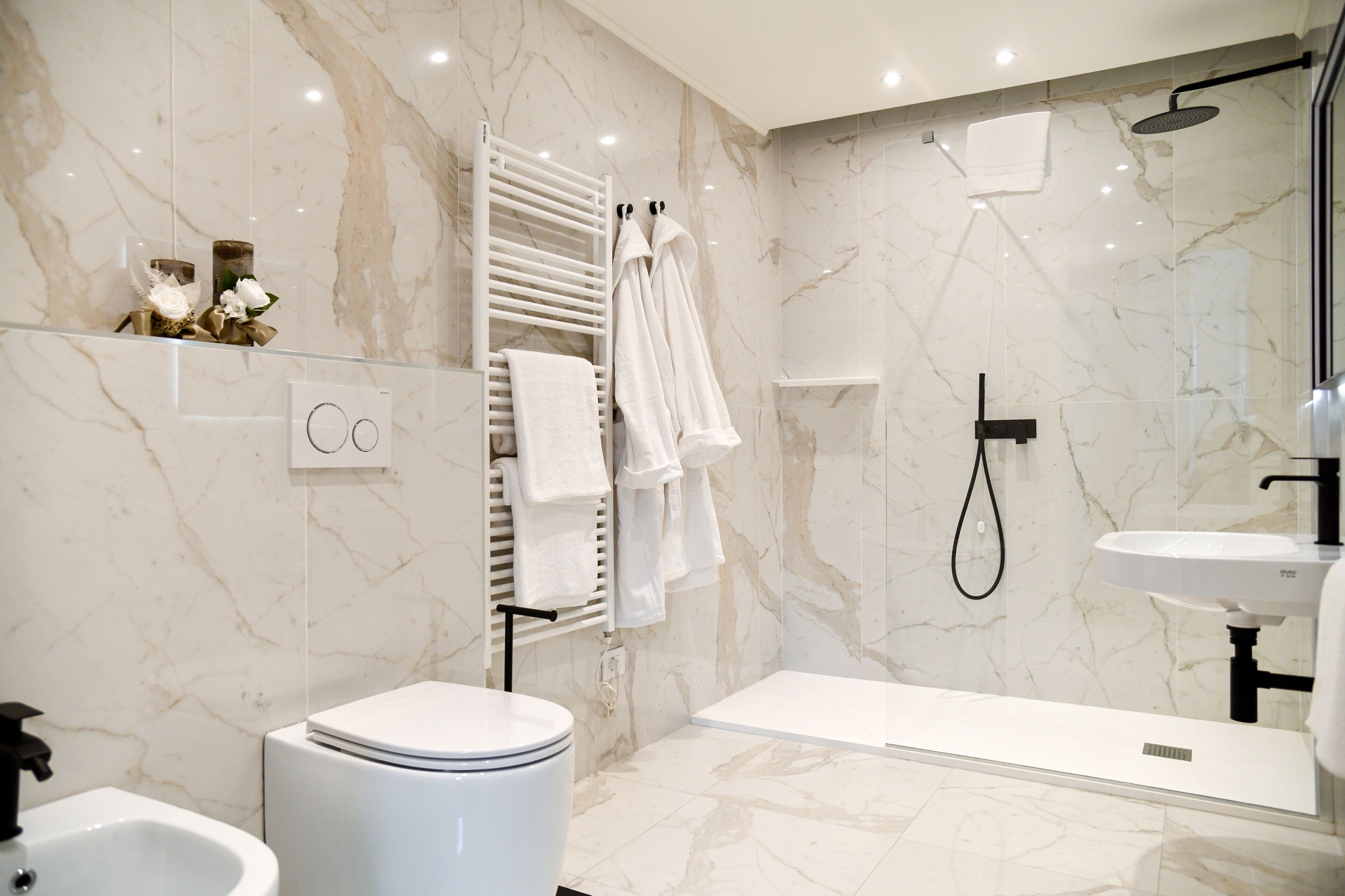 Une salle de bain moderne équipée de toilettes, d’un bidet et d’un espace douche.
