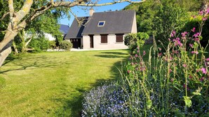 Een huis met een schuin dak, een klein raam en een verzorgd gazon.
