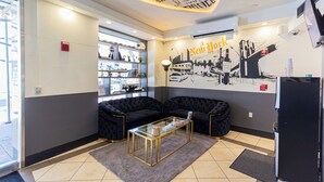 A modern living room with a sofa set, a glass coffee table, and a wall mural of New York City. - JGSTAY - Soho (New York)