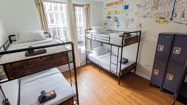 A dormitory room with bunk beds, a desk, a chair, and a window with curtains. - JGSTAY - Soho (New York)