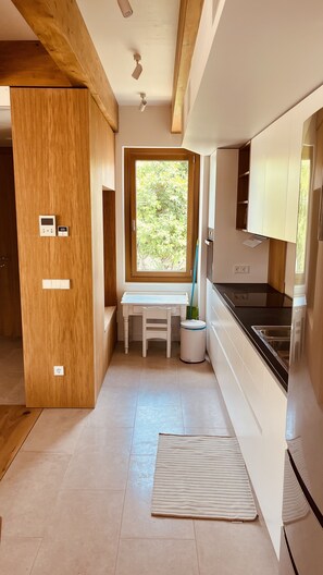 A modern kitchen with wooden accents, a built-in bench, a window with a view, and a sink.