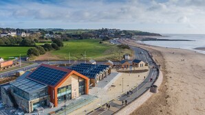 Un hôtel situé sur la côte, doté d’un design moderne, avec une façade en verre et des panneaux solaires.