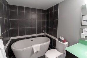 Een bad/douchecombinatie, een haardroger, handdoeken, zeep