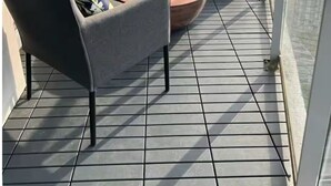 Un balcó amb seients de sofà, una taula de cafè i vista a la ciutat.