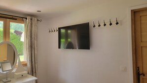Un bagno con specchio, mobile lavabo e TV a parete.