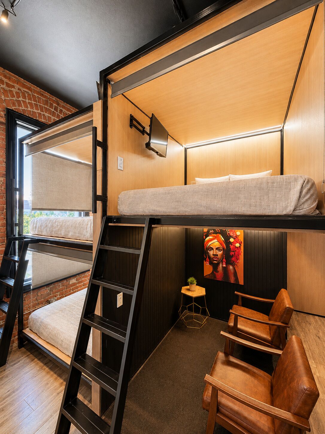 Une chambre avec un lit superposé, une échelle, un bureau, une chaise et une petite table sur laquelle est posée une plante.