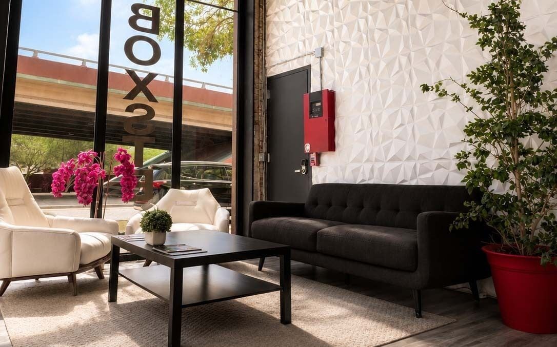A modern interior with a sofa, armchairs, a coffee table, and a potted plant.