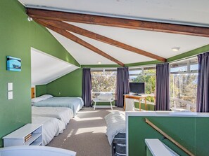 A room with a bunk bed, a desk with a computer, and a window with curtains. - Moeroa - Wharewaka Holiday Home (Wharewaka)