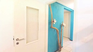 A hallway with a white door and a blue wall.