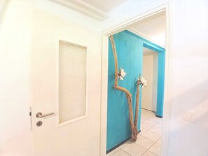 A hallway with a white door and a blue wall.