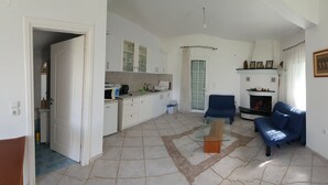 Ett rymligt vardagsrum med kök, matplats och en sittgrupp med soffa och soffbord.
