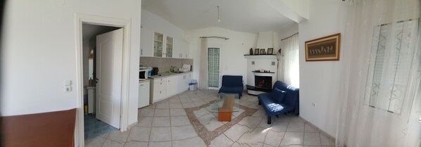 A spacious living area with a kitchen, a dining area, and a seating area with a sofa and a coffee table.