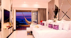 Ein Hotelzimmer mit zwei Betten, einem Fernseher, einem Balkon mit Blick auf den Abendhimmel und einer Hängematte.