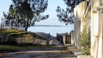 Une route étroite menant à un bâtiment d’où l’on a une vue sur la mer.