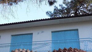 Un edificio con due porte blu e un balcone.