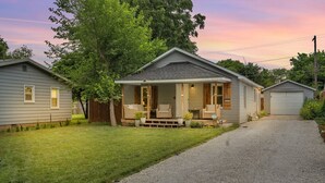 Et etplanshus med veranda, garage og en velplejet græsplæne.