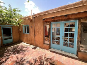 Stroll through the charming courtyard, featuring a rustic building with a flat roof and a large entrance.