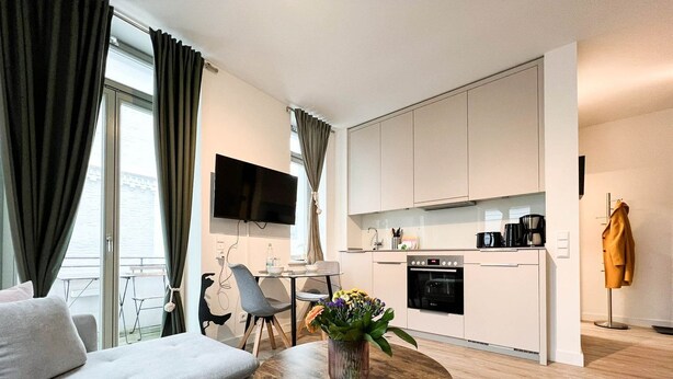 A modern apartment with a living room, dining area, and kitchen. - Anchorage - Enjoy your vacation close to the beach and the city center (Sylt)