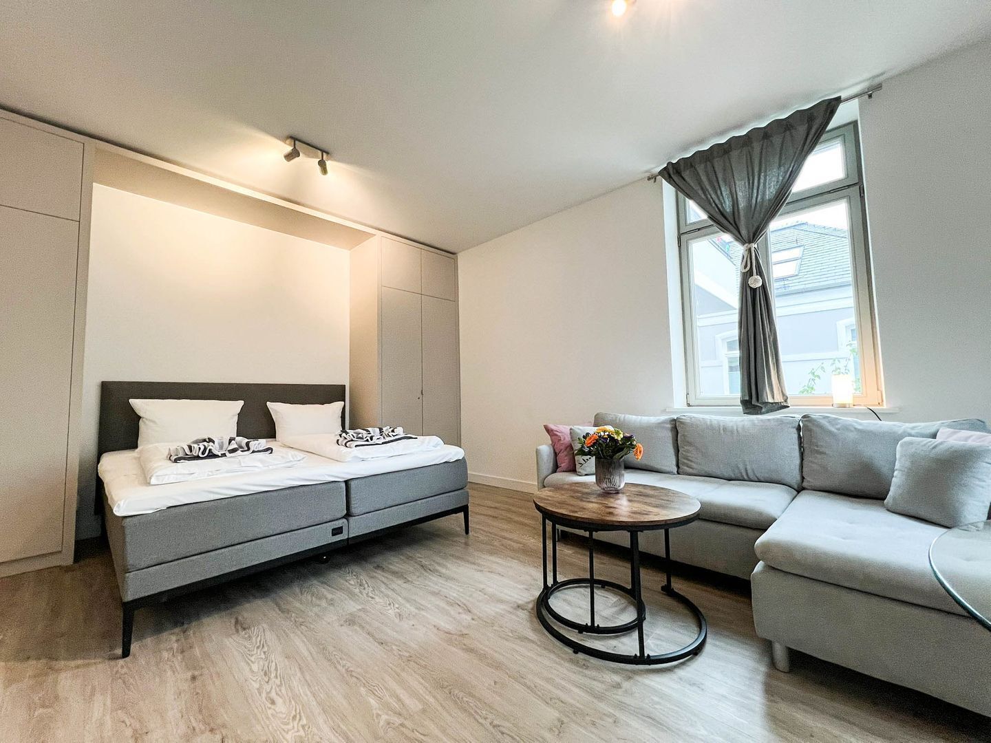A modern bedroom with a bed, a sofa, and a small table.