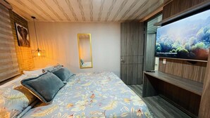 A bedroom with a bed, a mirror, a wardrobe, and a TV. - 502 Hermoso Apartamento Amoblado Movistar Arena (Bogotá)