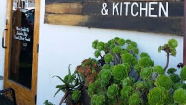 A building facade with a large sign reading "LITH & KITCHEN" and a door to the left. - Mile to Ocean! Fully Fenced Private SoCal Cottage (Oceanside)