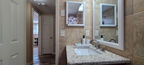 Een bad/douchecombinatie, een haardroger, handdoeken, zeep