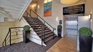 A staircase with a handrail, a sign reading "FRASER HOUSE", and a painting on the wall. - Aberdeen Stay Central 2-bedrooms Apt-no Party (Aberdeen)