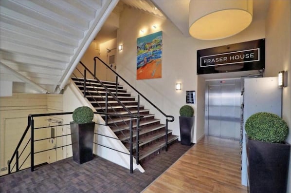 A staircase with a handrail, a sign reading "FRASER HOUSE", and a painting on the wall. - Aberdeen Stay Central 2-bedrooms Apt-no Party (Aberdeen)