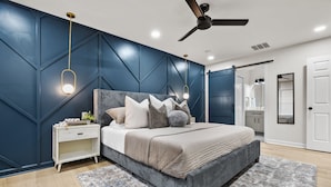 A bedroom with a bed, nightstand, and a ceiling fan.