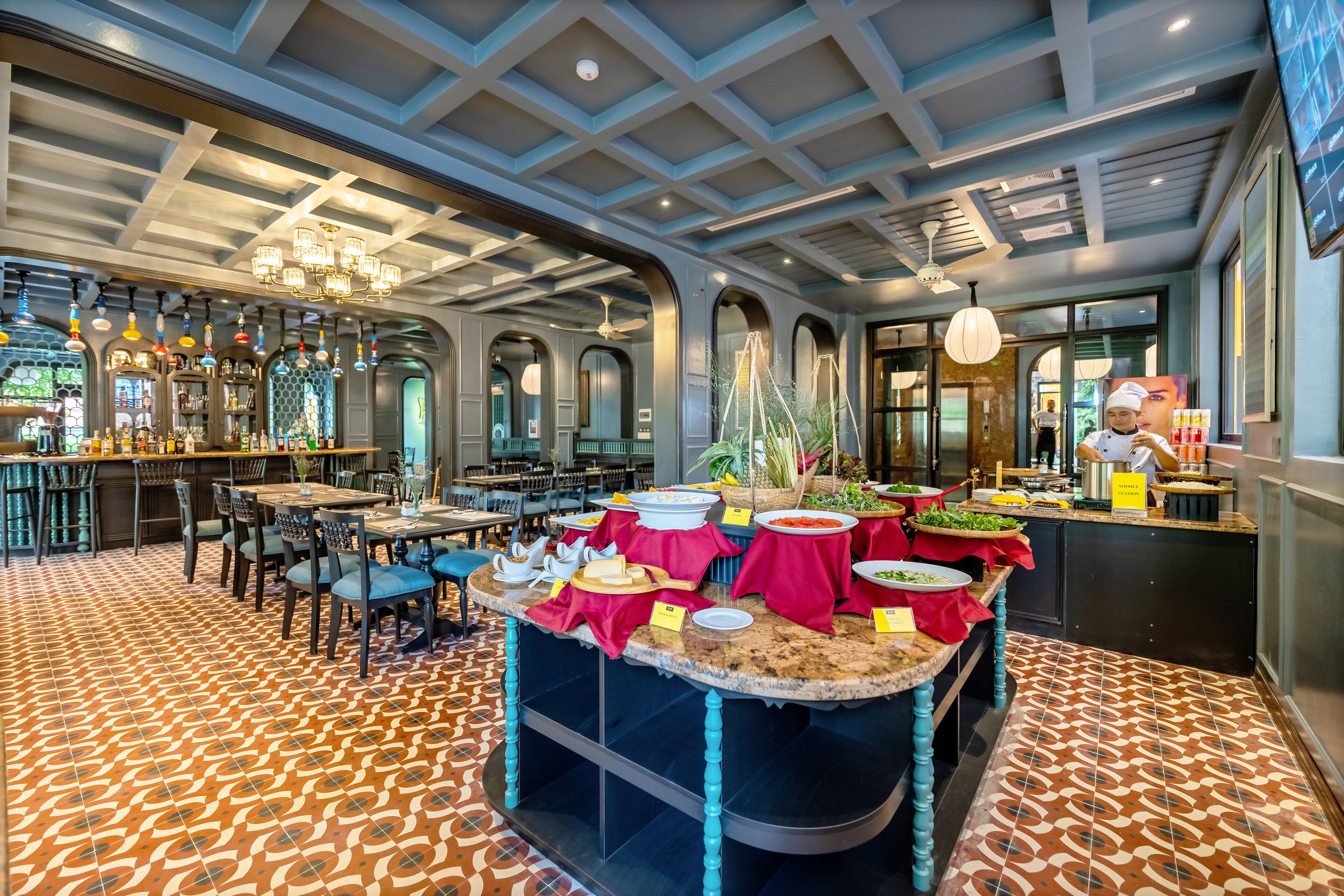 A restaurant with a bar area, multiple dining tables, and a buffet setup.