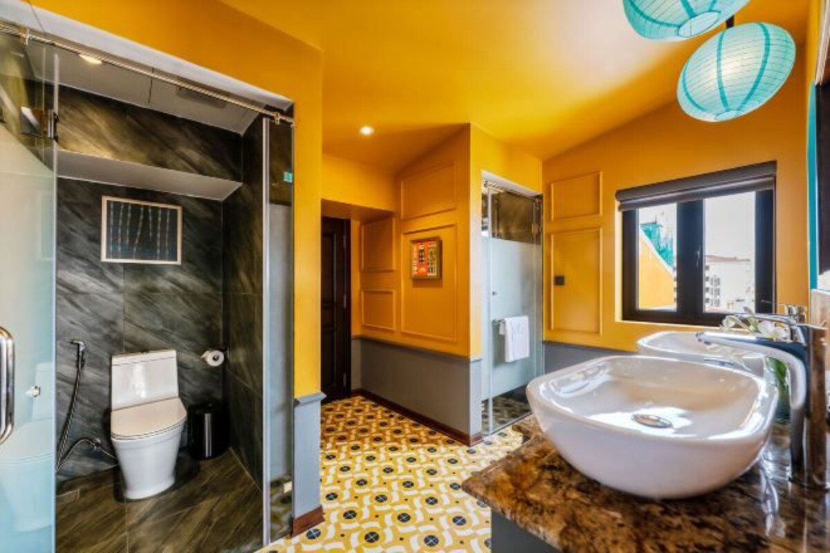 Une salle de bain moderne avec une douche en marbre, des toilettes, un lavabo et un carrelage décoratif.