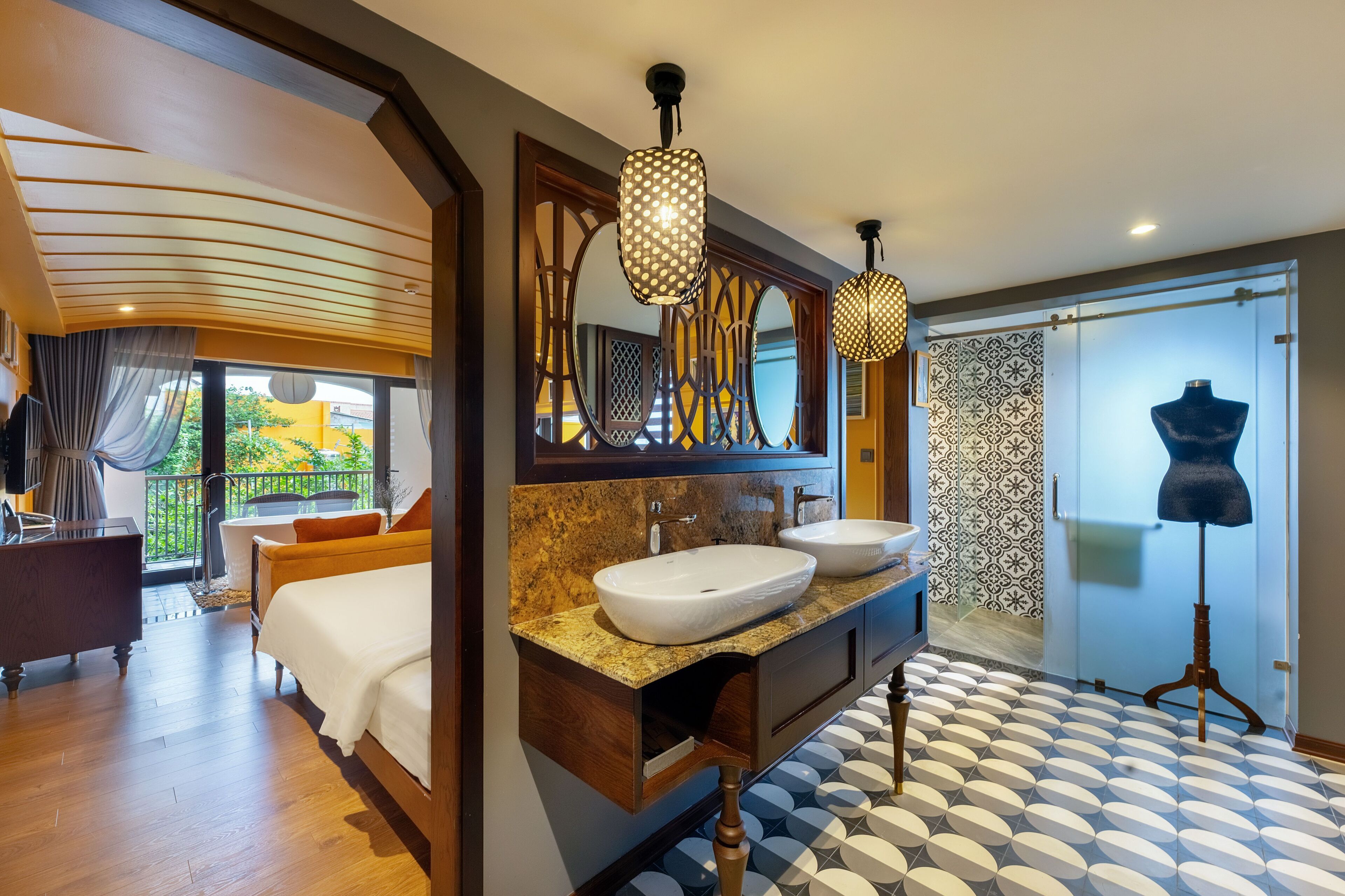 Une salle de bain d’hôtel moderne, dotée d’un double lavabo, d’un grand miroir et d’un luminaire encastré au plafond.