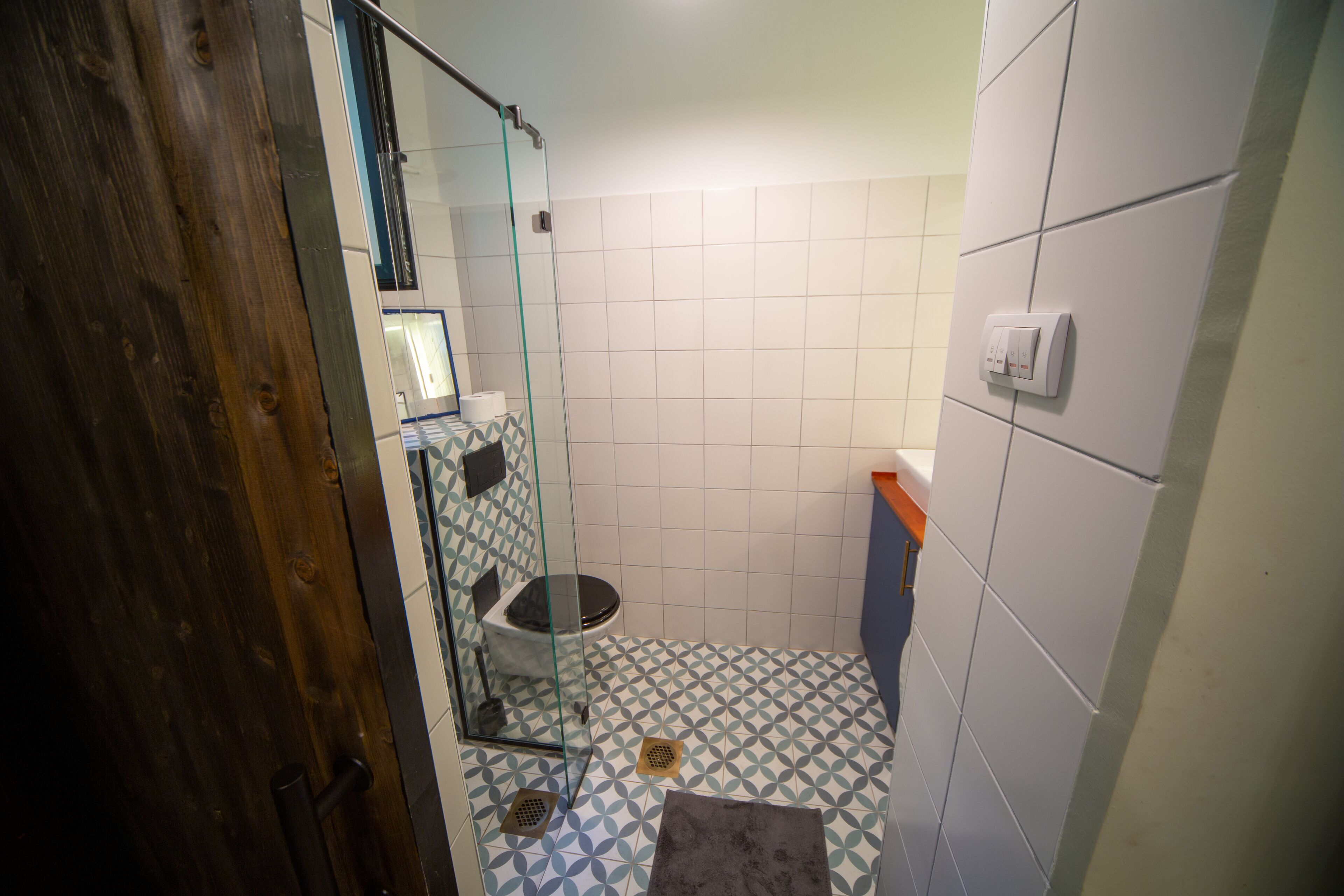 Een badkamer met een douchecabine van glas, toilet en wastafel.
