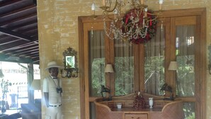 A room with a wooden desk, a mirror, a chandelier, and a mannequin. - Country House (Amparo)