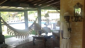 A room with a hammock, a table, and a statue. - Country House (Amparo)