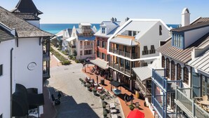 Uma cidade costeira com edifícios, uma rua e vista para o mar.