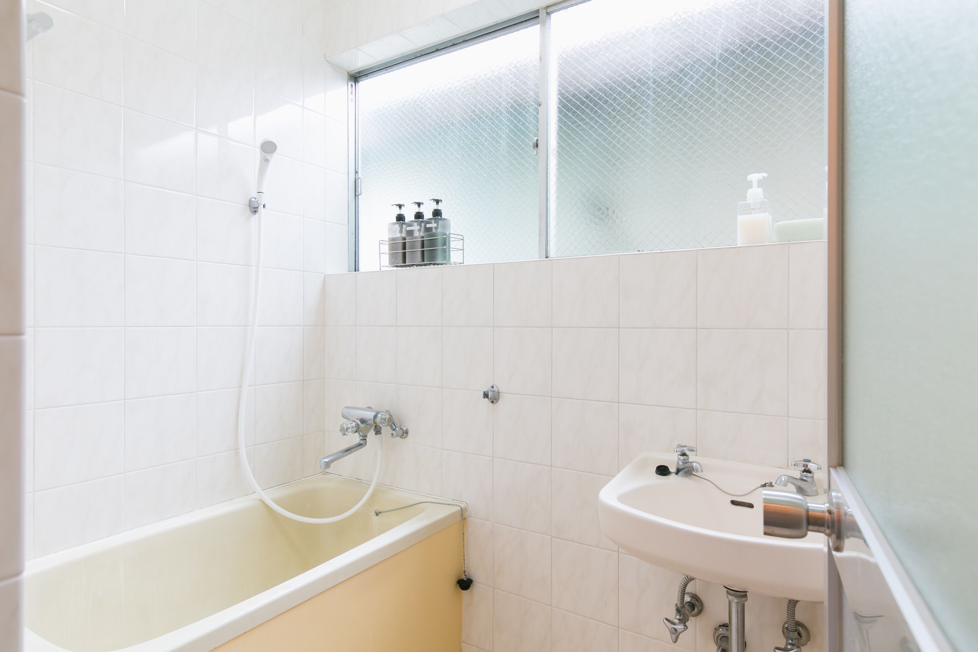 A bathroom with a bathtub, a sink, and a glass shower enclosure.