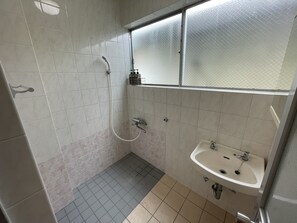 Bathroom features a shower, sink, and mirror.