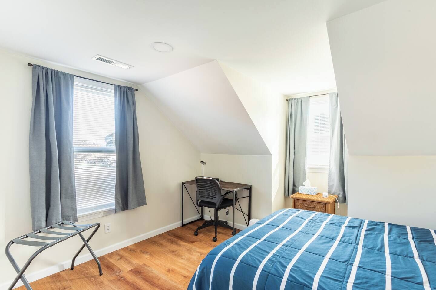 Un dormitorio con cama, escritorio y silla.