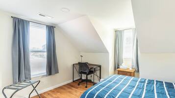 Un dormitorio con cama, escritorio y silla.