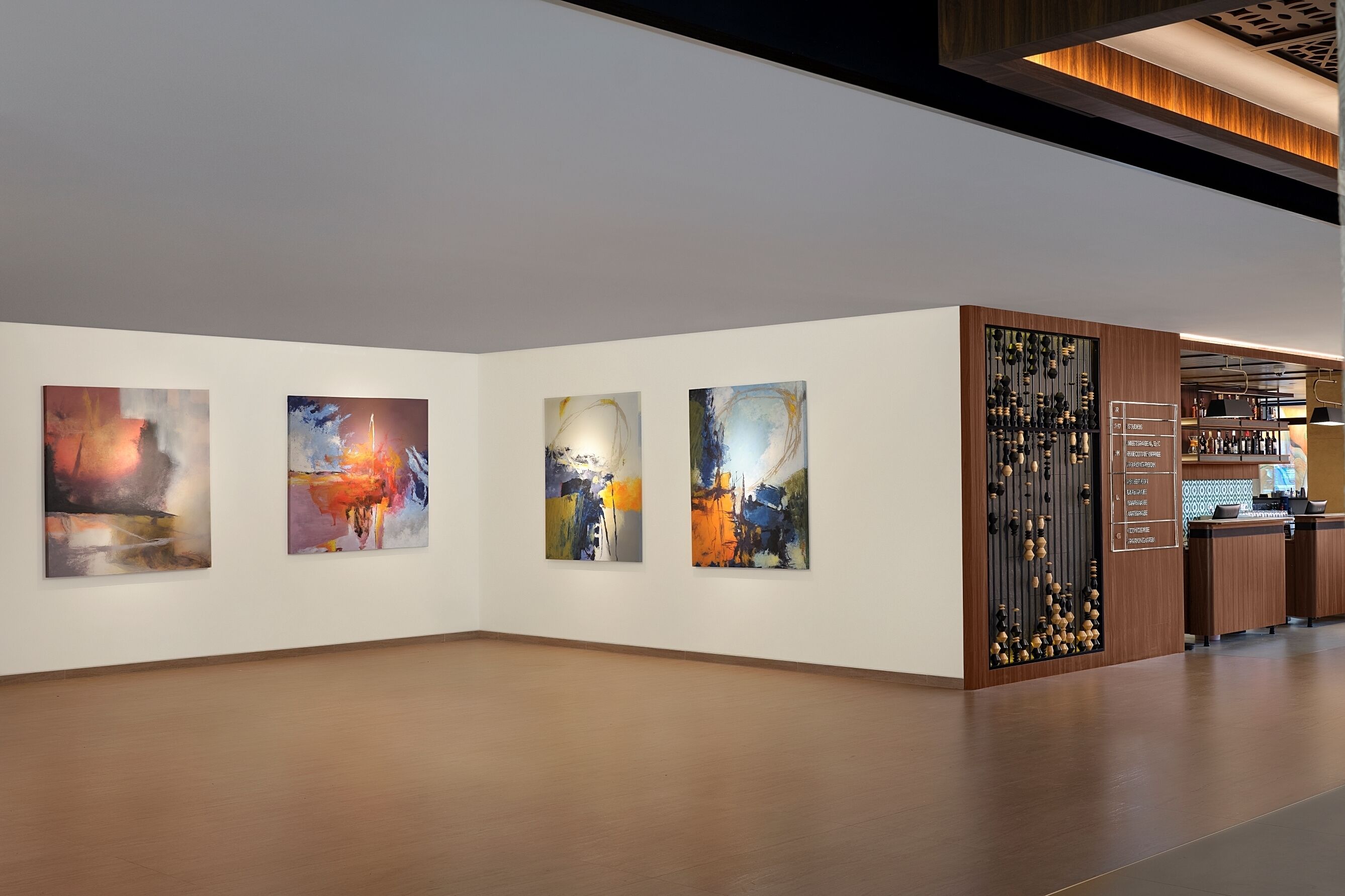 An art gallery with four abstract paintings on the wall.