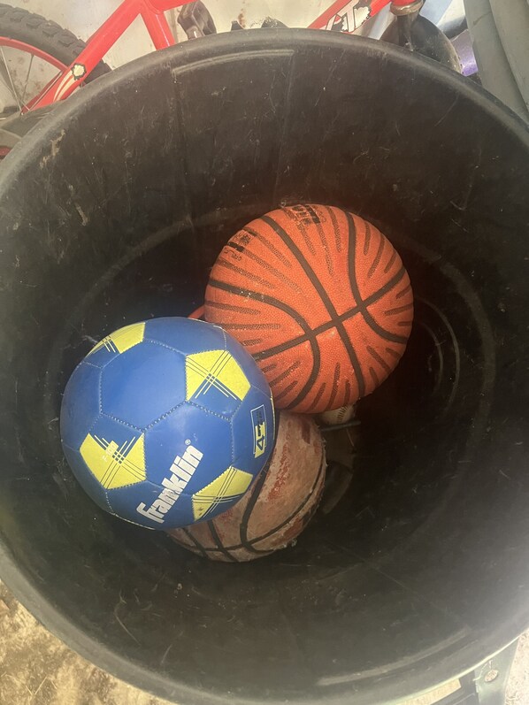A large black container holding a blue and orange soccer ball and a basketball. - Haven by the Lake (Yankton)